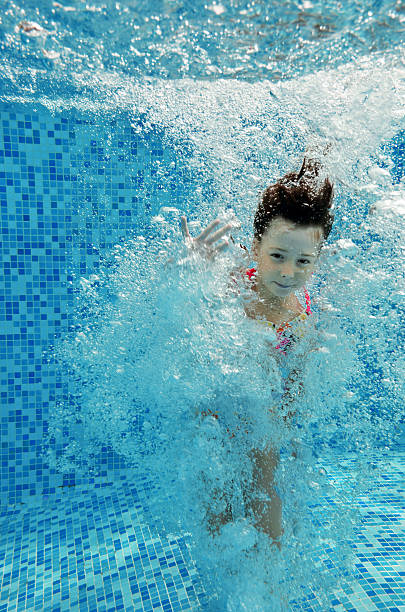 istock Happy smiling underwater child jumps to swimming pool 158556806
