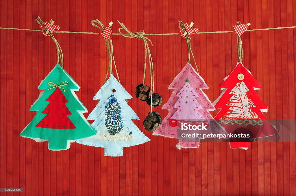 Homemade Christmas decoration over red background Homemade fir trees over red wooden background Christmas Present Stock Photo