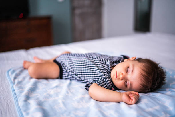 Baby boy sleeping on bed at the bedroom at home