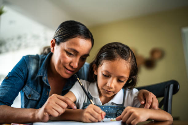 istock Mother helping daughter to study at home 1585589010