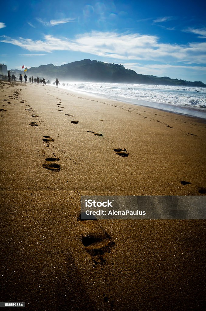 Walk on the mistic Beach Walk on the Beach; evening photo; water mist; people shapes unrecognizable; natural evening sunlight used. Atlantic Ocean Stock Photo