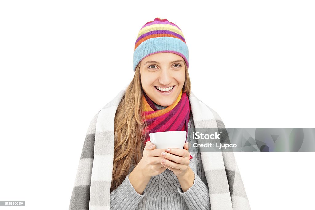 Donna sorridente coperto con una coperta con una tazza di tè - Foto stock royalty-free di Abbigliamento