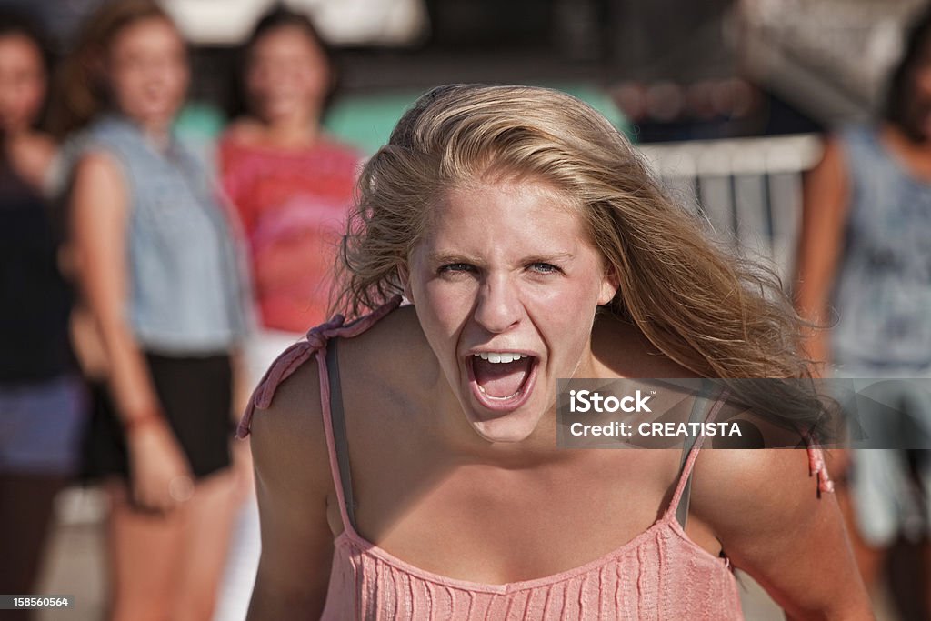 Screaming Teenage Girl Upset screaming young white teenager with group Screaming Stock Photo