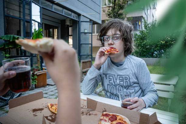 istock Children eating pizza in the garden. 1585609353