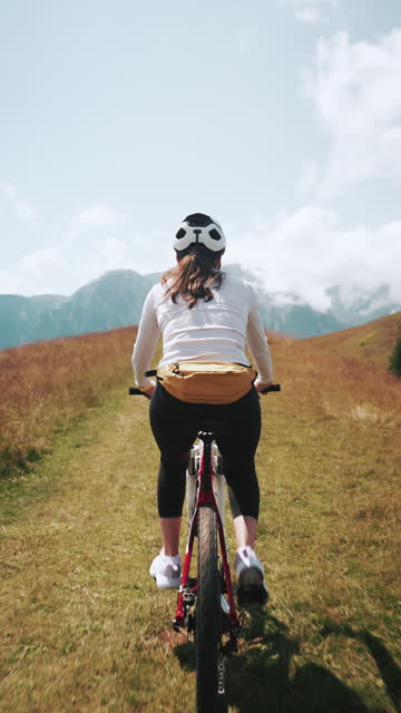 Young woman enjoying mountain biking on a sunny day.