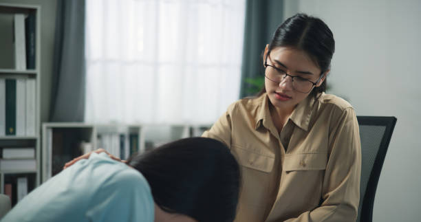 istock Young professional therapist touch on shoulder of female patient while crying 1585632320