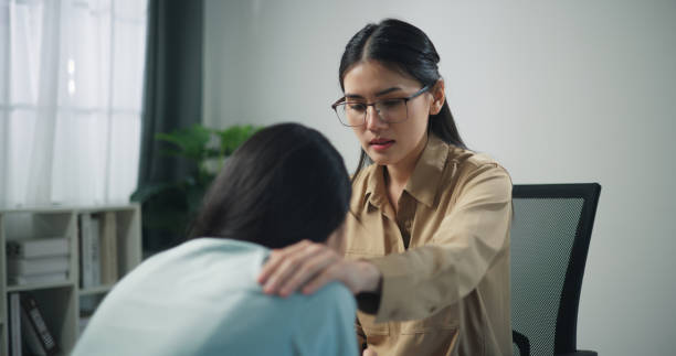 istock Young professional therapist touch on shoulder of female patient while crying 1585632331