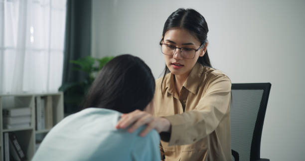 istock Young professional therapist touch on shoulder of female patient while crying 1585632338