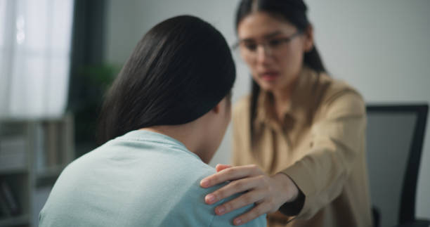 istock Young professional therapist touch on shoulder of female patient while crying 1585632340
