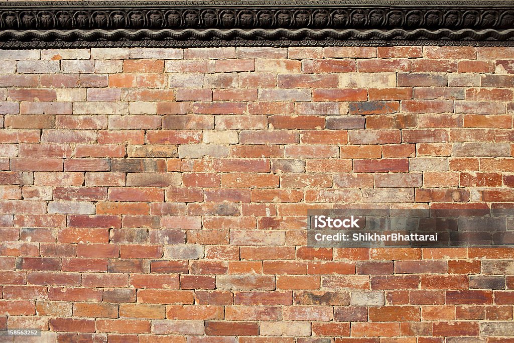 Muro di mattoni con un elaborato bordo di legno - Foto stock royalty-free di Bordo nero
