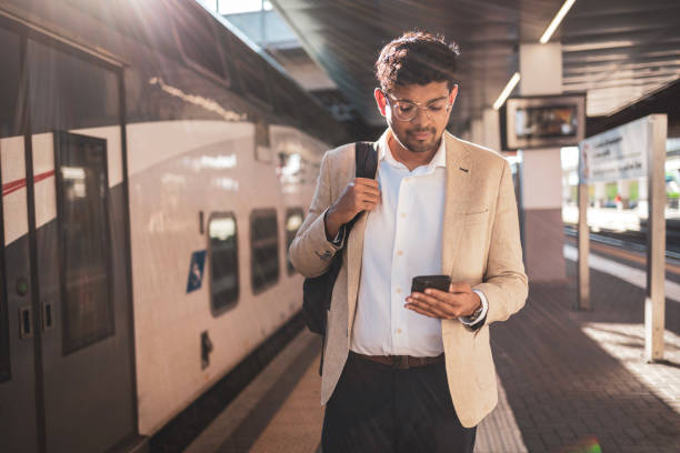 Millennial Indian businessman commuting for work. He is taking a train from the station .