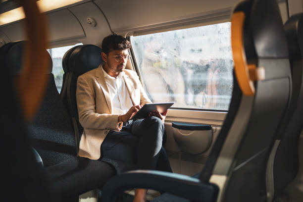 istock Millennial Indian businessman commuting for work. He is using digital tablet in the train. 1585645773