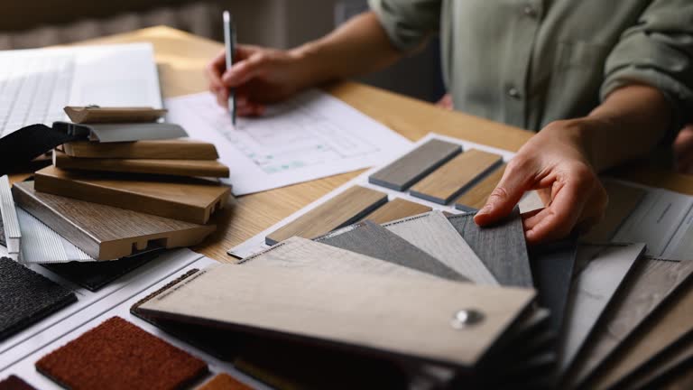 interior designer working on new house design project in office. choosing flooring and furniture materials and colors from samples