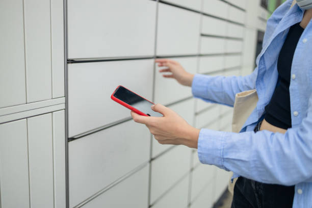 Woman client using automated self service post terminal machine or locker. Mail shipping concept