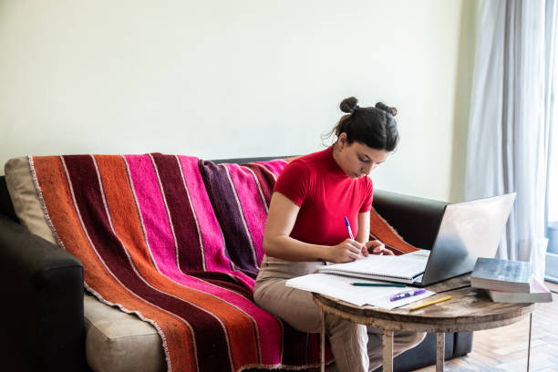 istock Young woman studying using laptop at home 1585675301