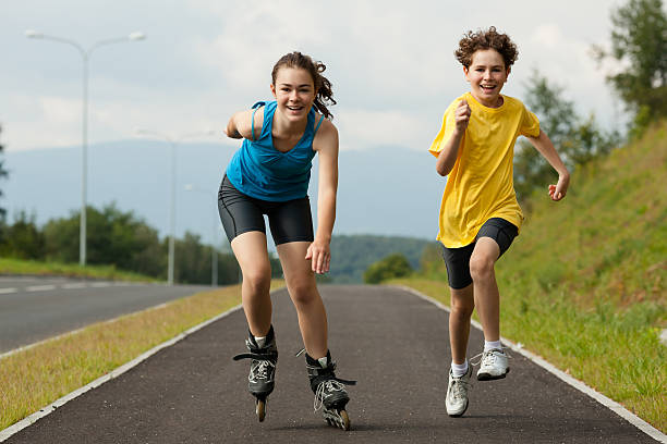 Girl and boy running, roller skating outdoor 