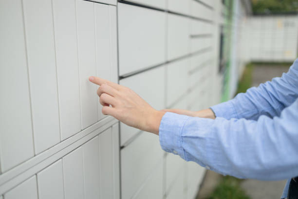 istock Woman client using automated self service post terminal machine or locker. Mail shipping concept 1585679549