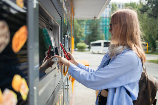 istock Woman client using automated self service post terminal machine or locker. Mail shipping concept 1585687976