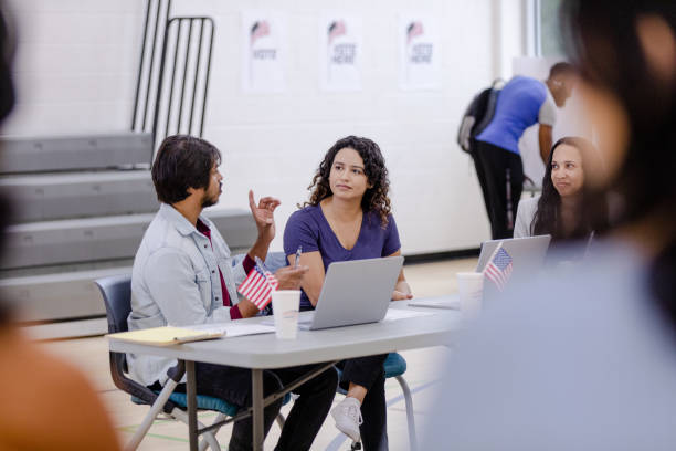 istock Diverse group of volunteers talk while working at the registration table 1585693454