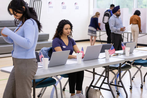 istock Female volunteers work together to organize data as it is received from the votes being placed 1585693468