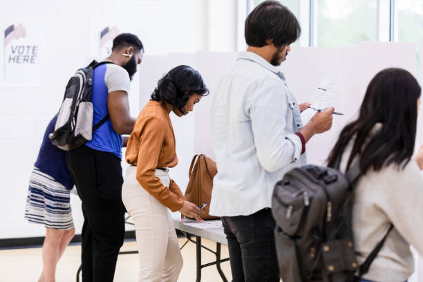 istock Diverse group of voters stand quietly at voting booths 1585693998