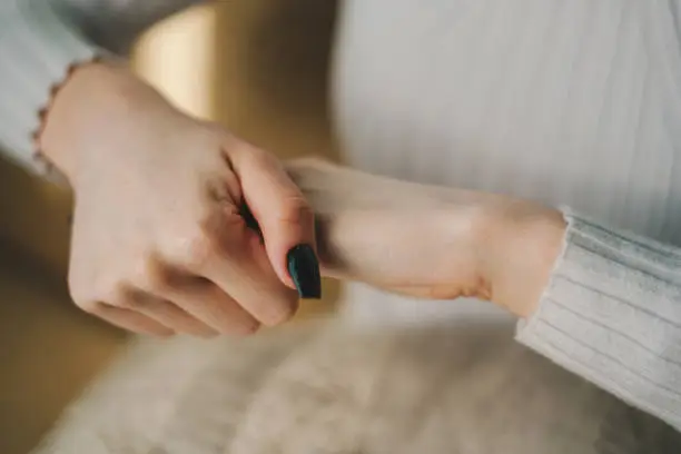 Closeup on woman's hands applying moisturizing hand-cream on. Skin care.