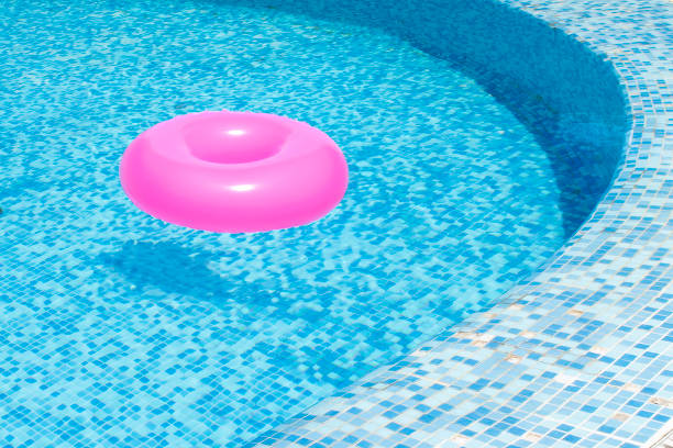 istock Pink Inflatable Ring Floating at Swimming pool. Swimming Pool in Summer 1585726071