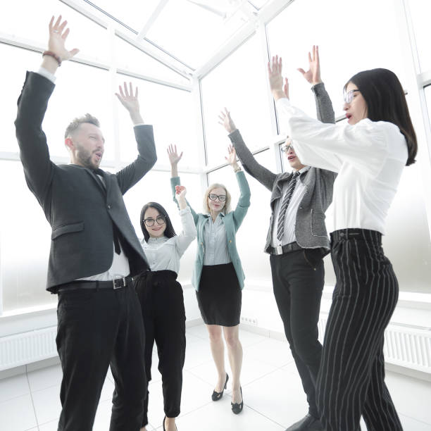 istock young business team holding their hands up 1585728336