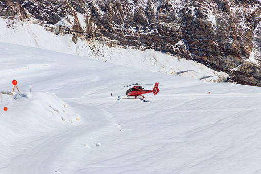 Disentis/Muster, Switzerland - 18 February 2014: Next to a landed Agusta A109SP rescue helicopter of Swiss Air-Rescue association \