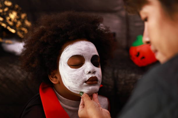 istock Mother and son getting ready for Halloween party,Face paint process 1585785069