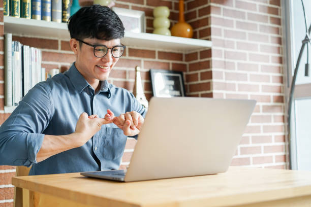 istock close up asian man make gesture hand of deaf sign language to teaching or learning from webinar in home for lifestyle concept 1585794787