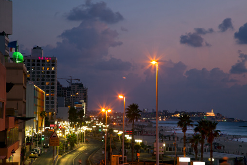 A view of the Tel-Aviv boardwalk and beaches at dusk, with the old city of Jaffa seen in the background. This image was shot on the Jewish holiday \
