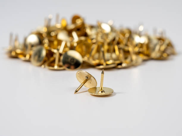 istock Pushpins of gold color on a white background. 1585807940