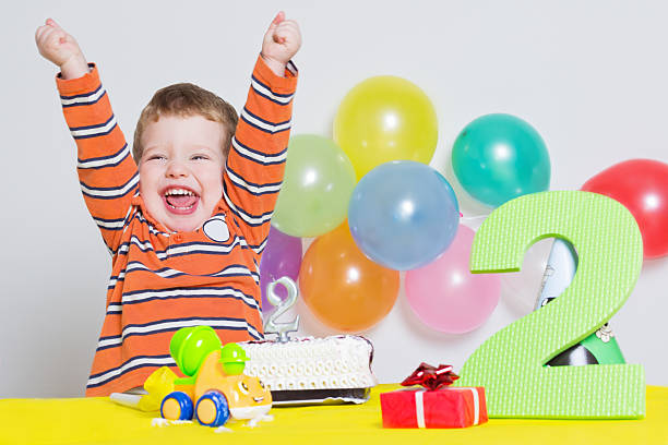 可愛らしい小さな男の子は彼にとって 2 回目の誕生日のお祝い - little cakes ストックフォトと画像