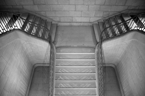 A grayscale shot of the stairs with handrails leading down to the old town in Austria.