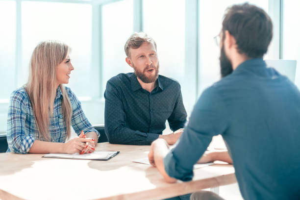 istock young man answering questions from managers during an interview. 1585896120