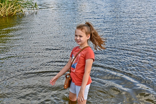 2 young boys and a young girl are jumping into a lake.  They have very happy faces and show alot of excitement