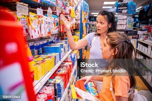 istock Mother and daughter shopping school supplies in a store 1585973163