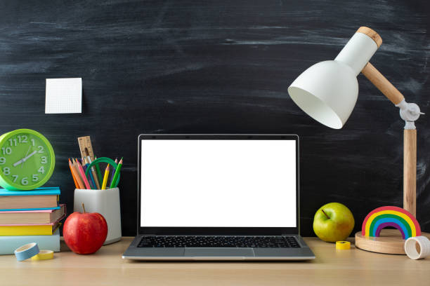 istock Step into the world of online studying from home with this captivating top-down view, presenting laptop and educational supplies on desk on blackboard background, copyspace for text or advertisements 1585981658