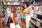 Mother and two daughters shopping school supplies in a store