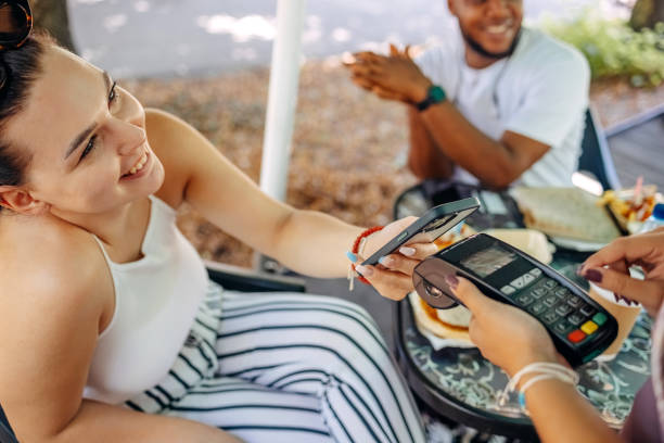 istock Paying in outdoor restaurant using smart phone 1585997060