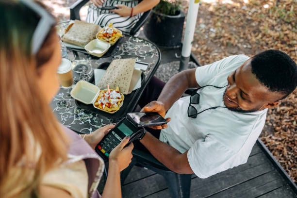 istock Paying in outdoor restaurant using smart phone 1585997571