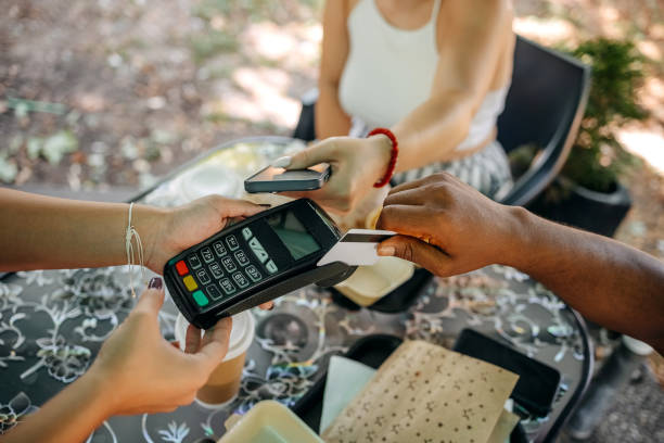 istock Couple paying bill in restaurant using plastic and smart phone 1585998119