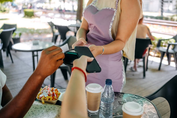istock Couple paying bill in restaurant using plastic and smart phone 1585998122