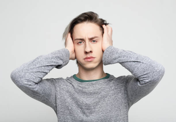 istock Stressed young man feel pain having terrible strong headache concept, tired upset guy massaging temples suffering from migraine 1586034619