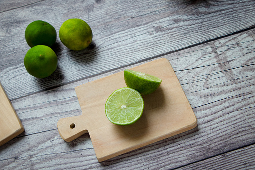 limones verdes en una tabla de cortar photo