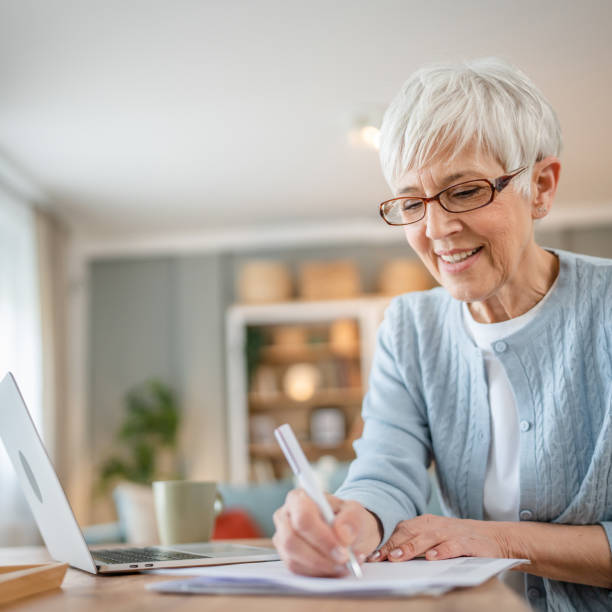 istock Senior caucasian woman use laptop computer at home for work 1586050123