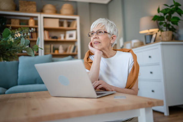 istock Senior caucasian woman use laptop computer at home for work 1586050645