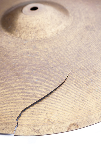 Old broken drum cymbal on white background