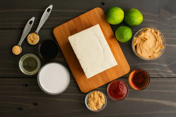 Bean curd surrounded with limes, peanut butter, and other ingredients for a vegan appetizer